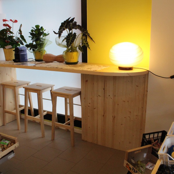 Progettazione e realizzazione di un negozio alimentari su misura. Bancone, tavoli, scaffalature, sedie; tutti elementi creati in legno per il cliente.